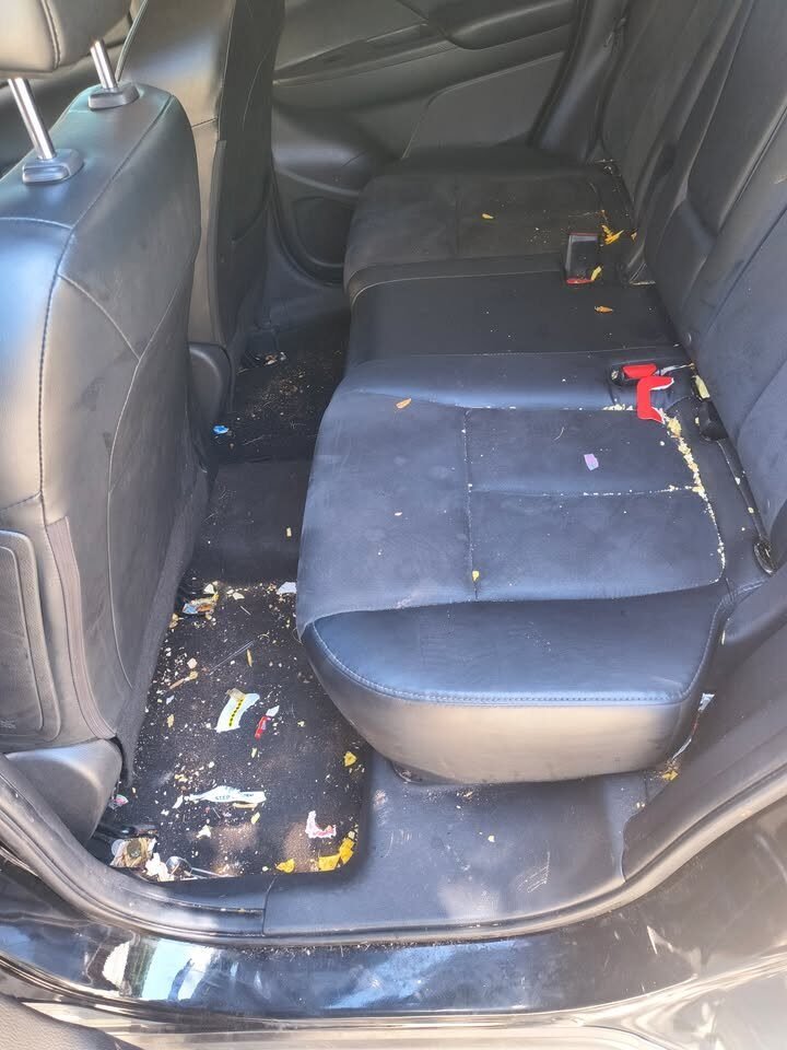 Before: Mitsubishi SUV back seat and floor covered in trash and stains before a Gleam Team interior detail in Charlotte and Raleigh NC